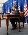 President Barack Obama signs the $787 billion American Recovery and Investment Plan into law at the Denver Museum of Nature and Science.