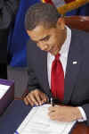 President Barack Obama signs the $787 billion American Recovery and Investment Plan into law at the Denver Museum of Nature and Science.