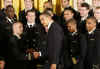 President Barack Obama presents the Commander In Chief Trophy to the Naval Academy Football Team in the East Room of the White House.