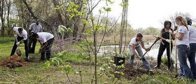 President Barack Obama and First Lady Michelle Obama plant trees with volunteers.