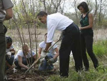 President Barack Obama and First Lady Michelle Obama plant trees with volunteers.