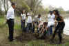 President Barack Obama and First Lady Michelle Obama plant trees with volunteers.