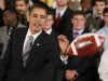 President Barack Obama meets with the NCAA National Football Champion Florida Gators in the East Room of the White House. President Obama passed the football to his aide Reggie Love.