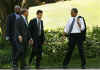 After greeting guests at the ceremony President Obama,  followed by White House aides, walked across the South Lawn to the Oval Office.