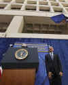 President Obama is introduced by FBI Director Robert Mueller who gives Obama an FBI cap and two teddy bears for daughters Sasha and Malia.