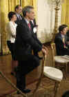 Chief of Staff Rahm Emmanuel listens to President Barack Obama speak at a prime time press conference on the 100th day anniversary of his presidency on April 29, 2009.