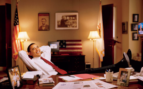 Senator Barack Obama relaxes in his Capitol Hill office in the fall of 2002. On the wall behind Barack Obama are photos of President Abraham Lincoln and Martin Luther King Jr.